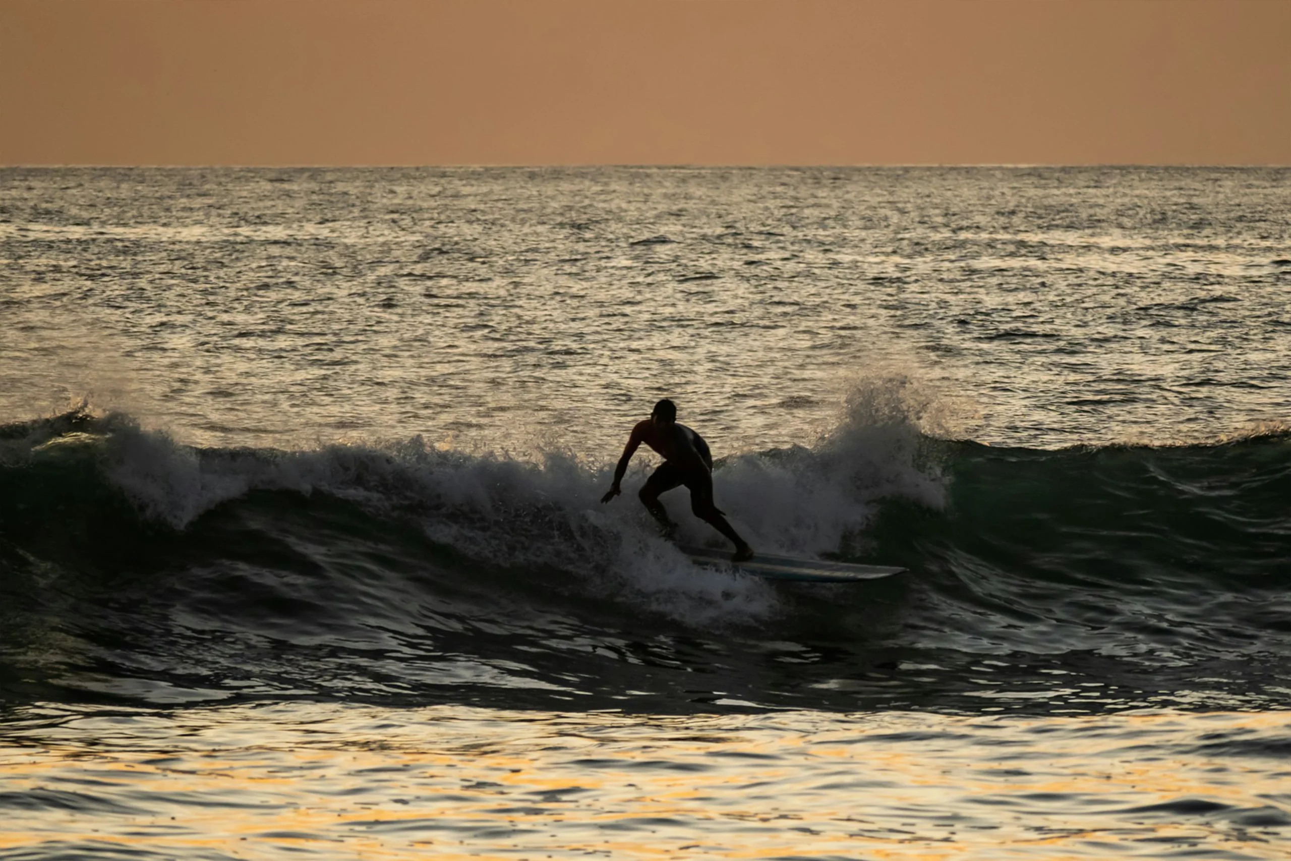 Surfer riding a wave at Playa Guiones Nosara