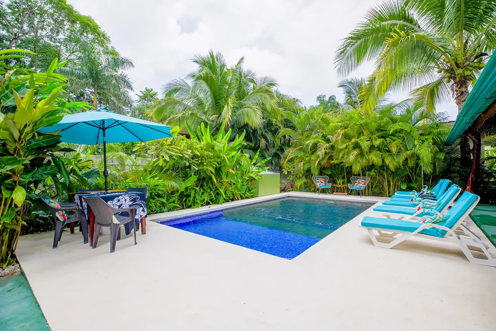 Shared swimming pool and tropical gardens at Cabinas Kahala